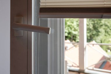 Güneşten koruyan yükseltilmiş perdeleri olan PVC kapısı. Yakın plan..