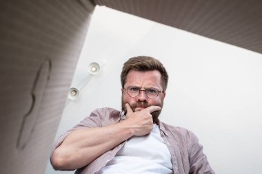 Düşünceli sakallı adam paketi bir paketle açtı, ne yapacağını şaşırdı, sipariş ettiği şeyi getirmedi. İçeriden bakıldığında boks. Yakın plan..