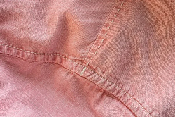 stock image Textured fabric background in pink color with stitches. Place for text. Flatley. Shirt sleeve detail. Close-up.