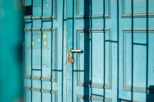 Stare Drewniane Drzwi Łuszczącą Się Niebieską Farbą Cieniem Tworzące Wzór — Zdjęcie stockowe