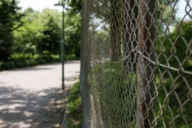 Parkta, bir yaz gününde zincirli metal tel örgüler. Yasak bölge. 