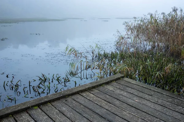 Ξύλινη Παλιά Προβλήτα Φόντο Μια Ήρεμη Λίμνη Ένα Ομιχλώδες Πρωινό — Φωτογραφία Αρχείου