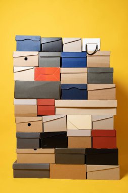 Sarı arka planda çeşitli ayakkabı kutuları var. Uzayı kopyala Satış konsepti. Yakın plan..