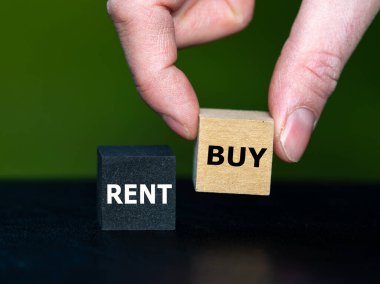 Hand selects the cube with the word buy instead of the cube with the word buy. Symbol for buying an object.