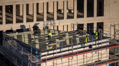 Roofer installing windows on the roof of a commercial building for a light well.