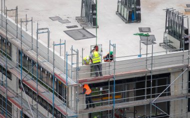 Glazier ticari bir binaya pencere kuruyor.