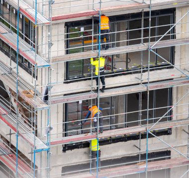 Glazier ticari bir binaya pencere kuruyor.