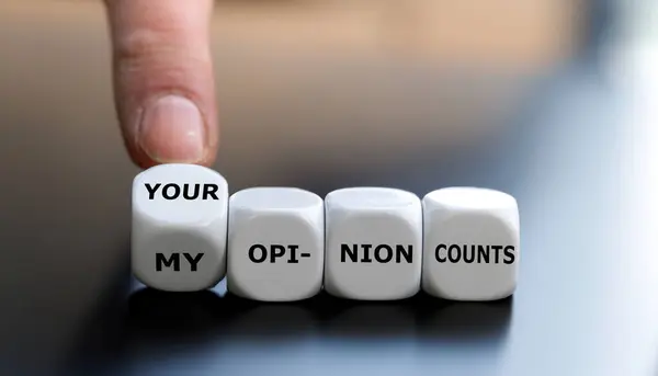 Hand turns dice and changes the expression \'my opinion counts\' to \'your opinion counts\'.