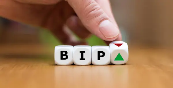 Hand changes the orientation of an arrow next to the abbreviation BIP (the German abbreviation for Gross domestic product) indicating a new trend of the economy.