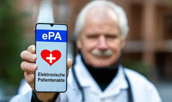 A doctor is holding a mobile phone with the text \'ePA elektrosche Patientenakte\' (electronic health records). Symbol for the start of the electronic health records app in Germany in 2025.