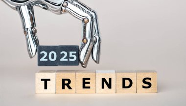 Robot el '2025 trendleri' ifadesini taşıyor. 2025 yılında çok daha fazla yapay zekanın sembolü..