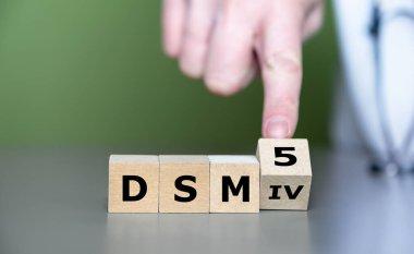 El küpü döndürür ve 'DSM IV' ifadesini 'DSM 5' olarak değiştirir. DSM (Zihinsel Bozuklukların Teşhis ve İstatistiksel El Kitabı) kılavuzunun güncellenmesi için sembol.