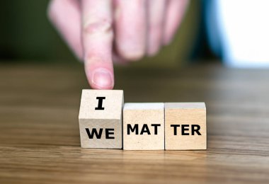 Hand turns cube and changes the expression 'we matter' to 'I matter'. clipart