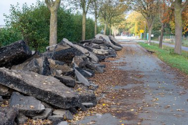 Road construction in Germany. Crushed concrete blocks of the old street on a country road. clipart