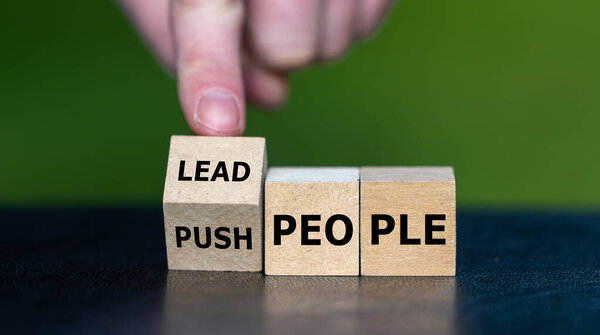 Wooden blocks showing Lead people instead of Push people, symbolizing positive leadership, guidance, teamwork, motivation, and inspiring others in business and workplace culture.