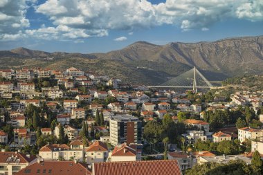 Dubrovnik 'in terasotta çatılarına bakan, dağlık bir zemin üzerine kurulmuş modern bir asma köprü..