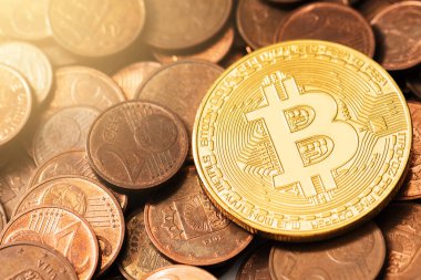 Bir yığın bakır euro sikkesi üzerinde parlak altın bir bitcoin 'in yakın çekimi.