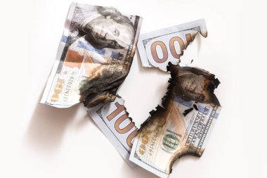 Yırtılmış ve yanmış yüz dolarlık banknotların yakın çekimi. Ekonomik kriz, enflasyon ve iş başarısızlığı kavramı.