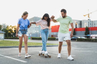 Üç farklı kaygısız arkadaş eğleniyor ve otoparkta sörf yapıyor.