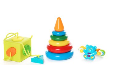Küçük çocuklar için renkli plastik oyuncaklar ve yapboz koleksiyonunun yakın çekimi, mantığın gelişimi ve beyaz arka planda iyi motor becerileri için iyidir..