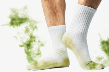 Beyaz arka planda pis kokulu çorapları olan erkek ayakları