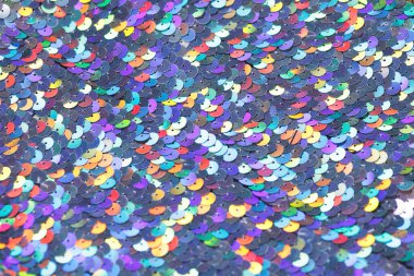 Closeup shot of a shiny multicolored sequin fabric made of linked colorful metallic circles. clipart
