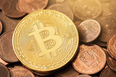 Bir yığın bakır euro sikkesi üzerinde parlak altın bir bitcoin 'in yakın çekimi.
