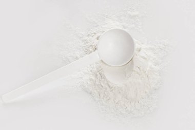 Closeup of scoop with creatine monohydrate supplement  clipart