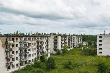 Issız bir Avrupa hayalet kasabasında, pencereleri kırık, terk edilmiş bir apartmanın dışında..