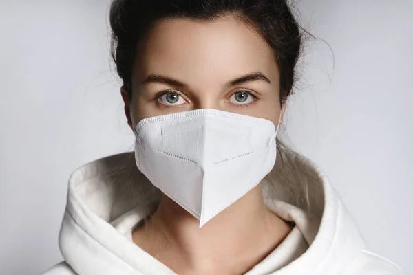 Junge Frau Mit Weißem Kapuzenpullover Und Ffp2 Atemschutzmaske Vor Grauem — Stockfoto