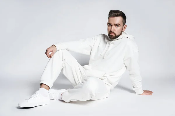 Handsome Man Wearing Blank White Hoodie Pants Sitting Light Gray — Stock Photo, Image