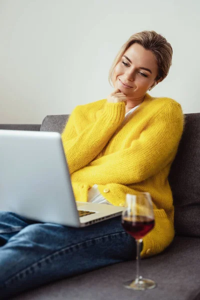 Junge Frau Sitzt Auf Dem Sofa Und Trinkt Rotwein Während — Stockfoto