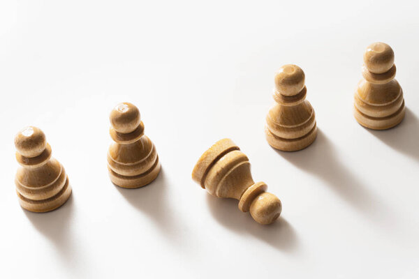 Крупный план деревянных шахматистов, стоящих с одной пешкой в руках. Концепция социальной проблемы и запугивания.