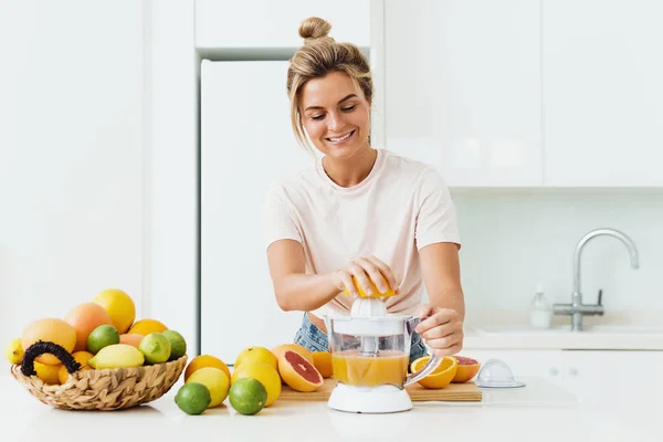 Jonge Vrolijke Vrouw Met Veel Citrusvruchten Tijdens Vers Sinaasappelsap Bereiding — Stockfoto