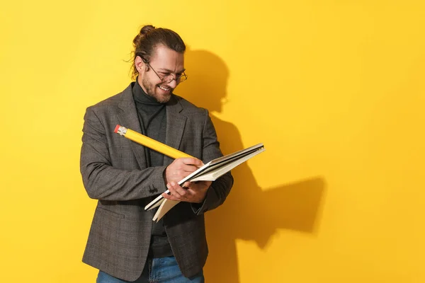 Gözlüklü Neşeli Sakallı Adam Sarı Arka Planda Büyük Bir Kalem — Stok fotoğraf