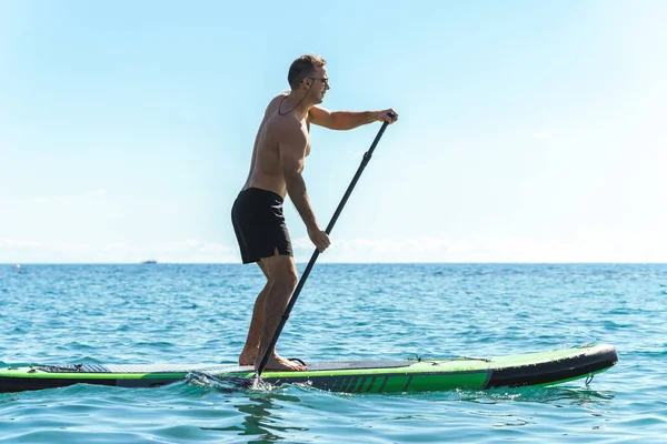 Fiatal Férfi Szörfös Egy Állódeszkán Evez Egy Evezővel Óceánban — Stock Fotó