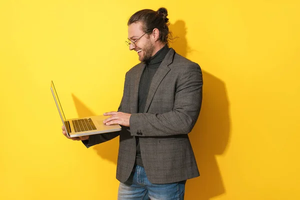 Schöner Bärtiger Mann Mit Brille Benutzt Laptop Auf Gelbem Hintergrund — Stockfoto