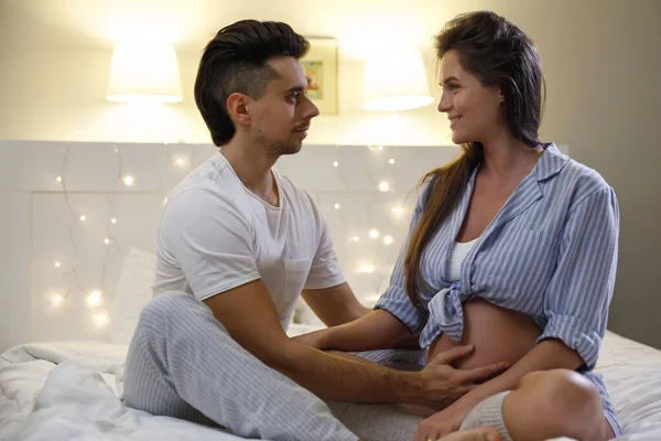 若い夫婦が赤ん坊を待っている 夫と妊娠中の妻は家のベッドでリラックス — ストック写真