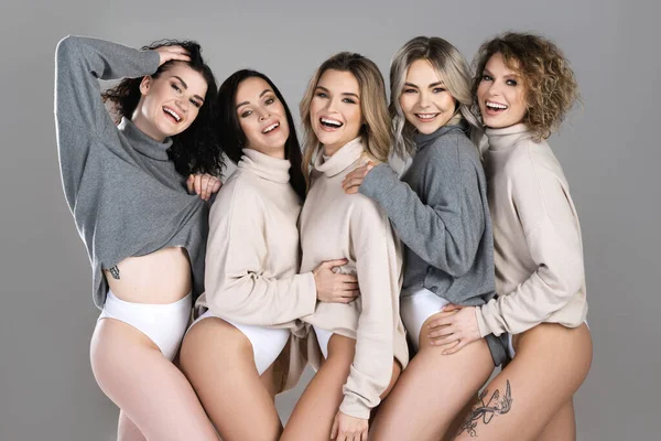Group of different women wearing turtleneck jumpers on gray background. Diversity, friendship and other concepts.