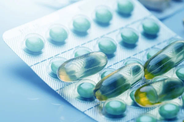 Különböző Tabletták Kapszulák Közelsége Orvosi Kék Fényben — Stock Fotó