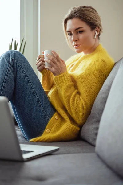 Mujer Joven Con Taza Café Caliente Sentado Sofá Uso Computadora — Foto de Stock