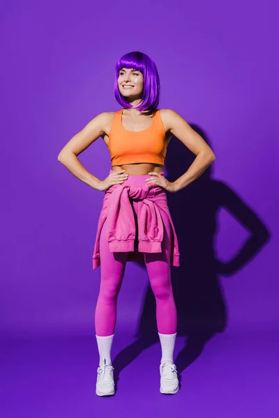 Портрет Веселой Женщины Разноцветной Спортивной Одежде Сидящей Фиолетовом Фоне — стоковое фото