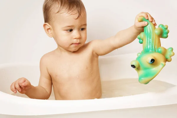 可爱的小男孩在温水里洗澡的时候 正在和一条橡胶鳄鱼玩耍 — 图库照片