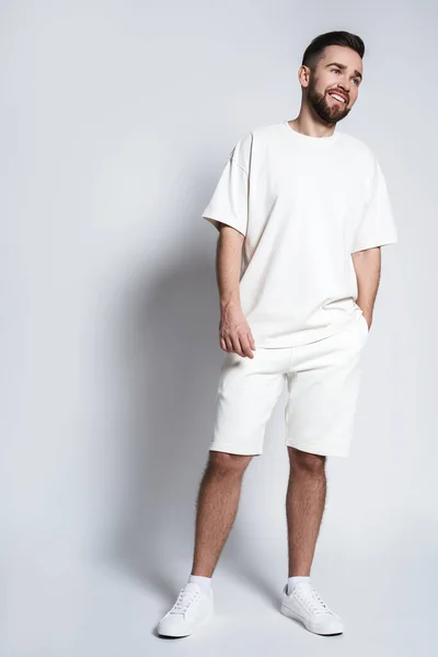 Schöner Mann Mit Weißem Sweatshirt Und Kurzen Hosen Vor Grauem — Stockfoto