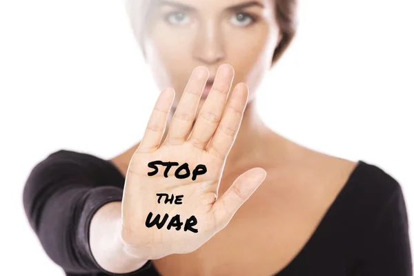 Woman activist showing her palm with STOP THE WAR phrase on white background