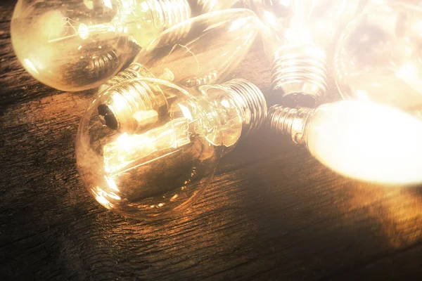 Closeup of glowing warm light bulbs on wooden surface