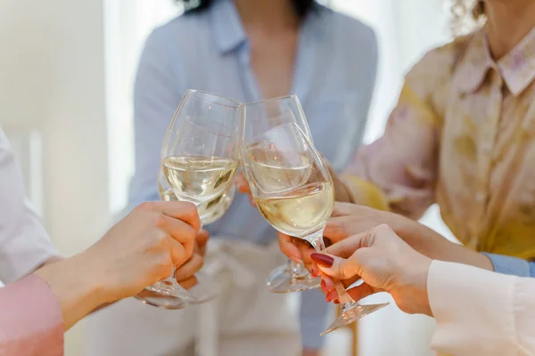 ホワイトワインで満たされたメガネをクリックして若い女性の友人のクローズアップショット — ストック写真