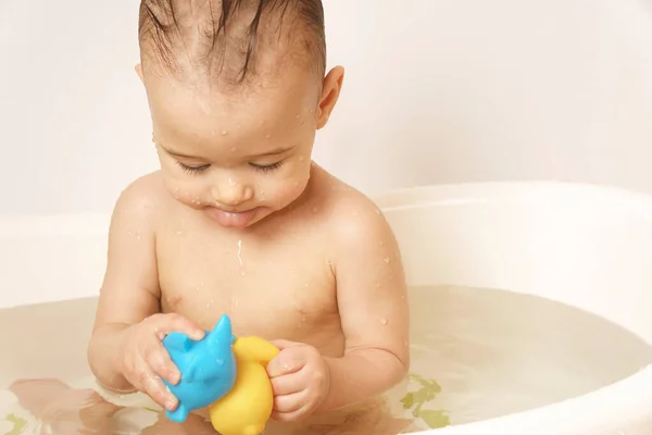 可爱的小男孩一边在温水中洗澡一边玩橡胶玩具 — 图库照片