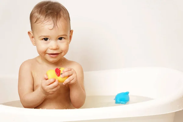 Uroczy Chłopiec Bawi Się Gumową Kaczką Podczas Kąpieli Ciepłej Wodzie — Zdjęcie stockowe