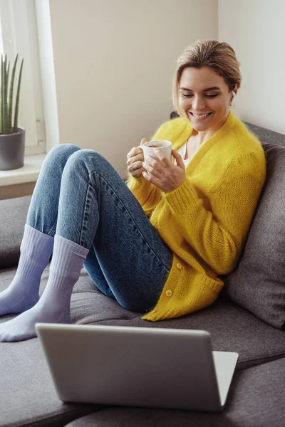 Mujer Joven Con Taza Café Caliente Sentado Sofá Uso Computadora — Foto de Stock